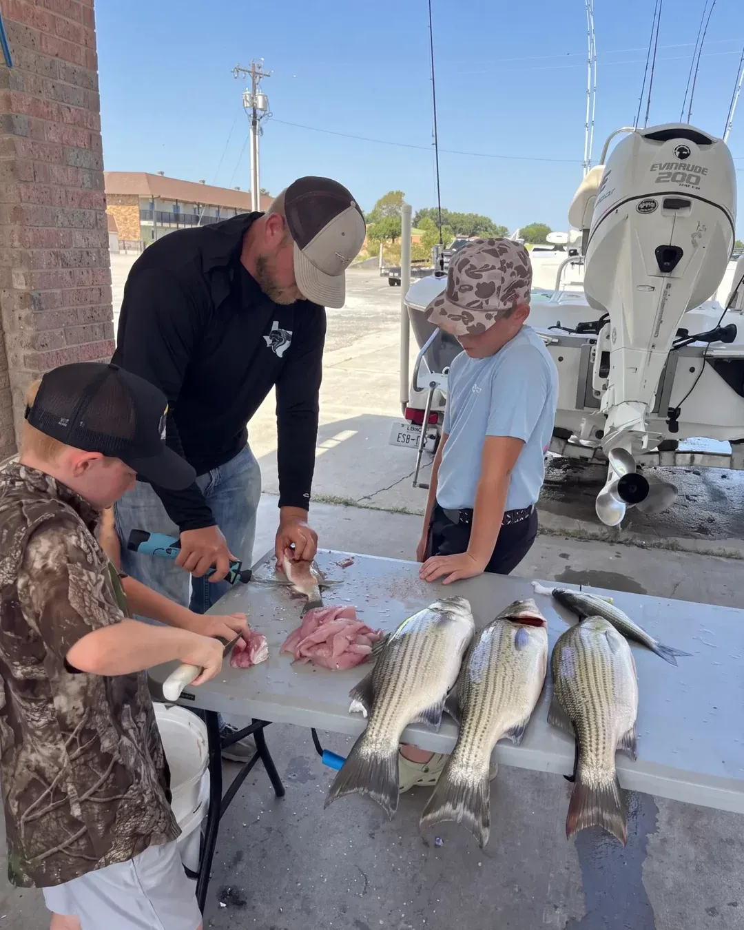Cleaning the morning's catch at the table with two young anglers after a Lake Bridgeport trip