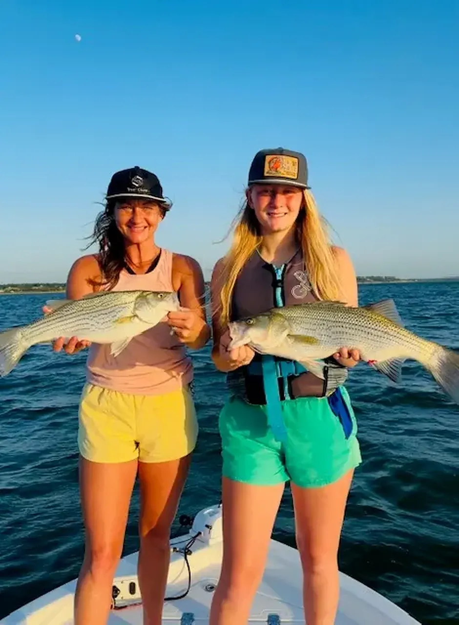 Two anglers holding hybrid stripers caught on Lake Bridgeport